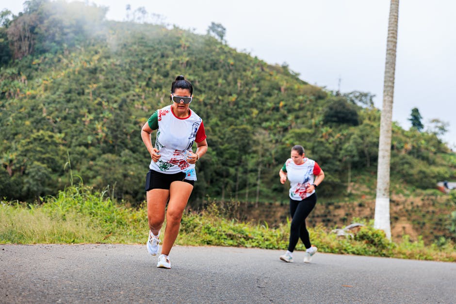 Deux traileuses courant en montagne dans un paysage verdoyant